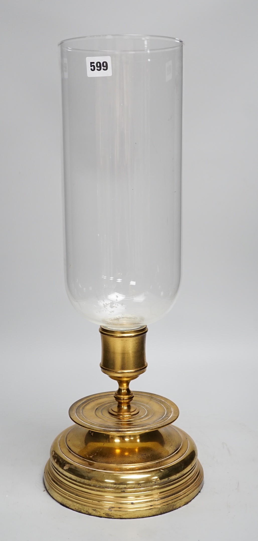 Three matching brass and glass storm lanterns, 49cms high